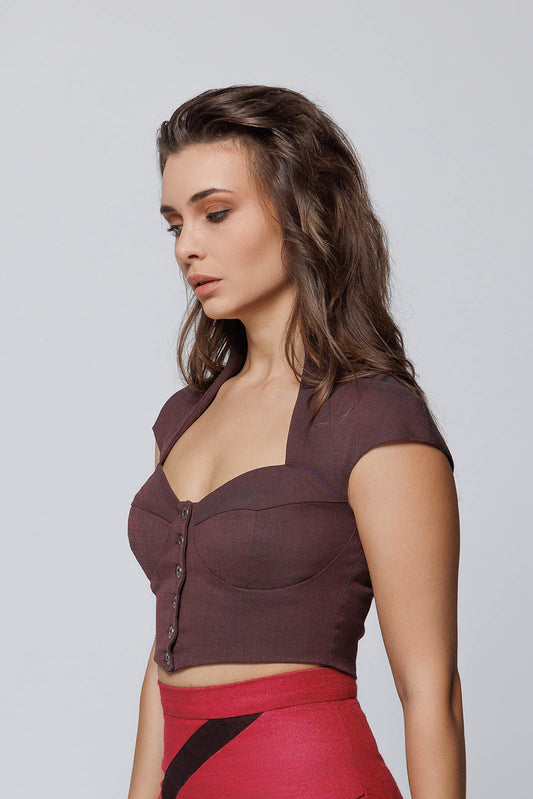 Side profile of a tailored maroon bralette top, worn by a model showing the cap sleeves and sculptural bust contouring.