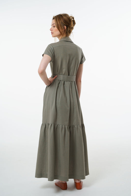 Back view of olive green linen button‑down maxi dress with belted waist and gathered tiered skirt, worn by a model.skirt.