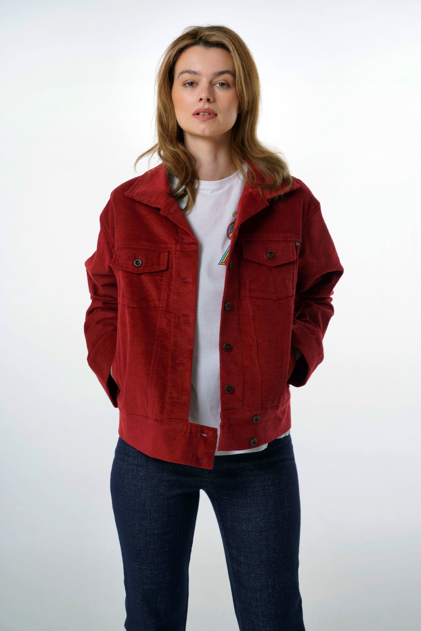 Front view of a vintage-inspired dark red corduroy jacket for women, worn by a model, featuring dual chest pockets and a boxy, modern fit.