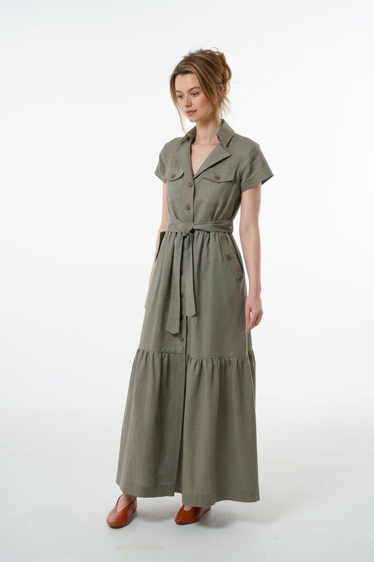 Olive green linen button‑down maxi dress with short sleeves, belted waist, and tiered hem, worn by a model, front studio view.