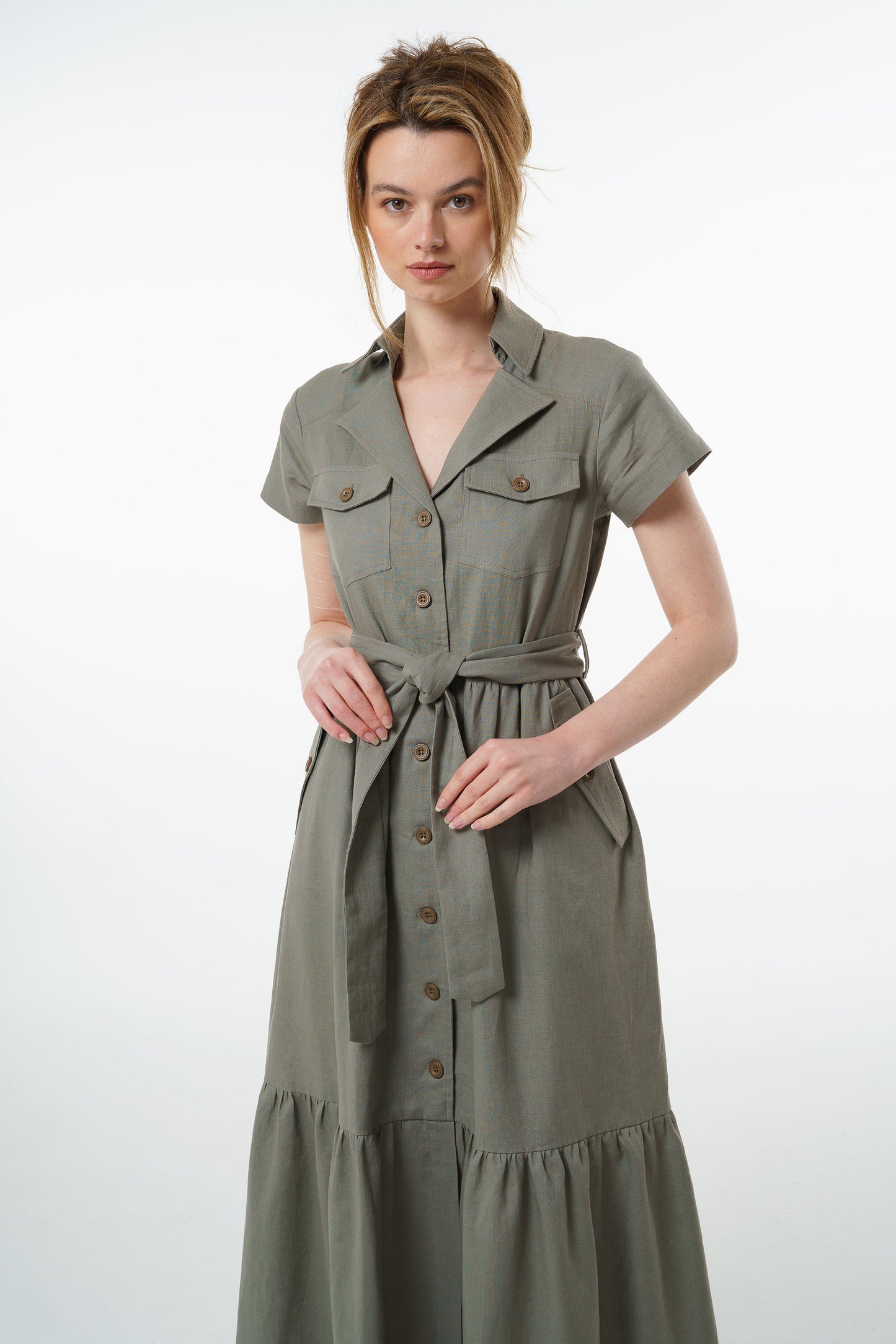 Olive green linen maxi dress with button front, belted waist, and gathered tiered hem, worn by a model, front studio view.