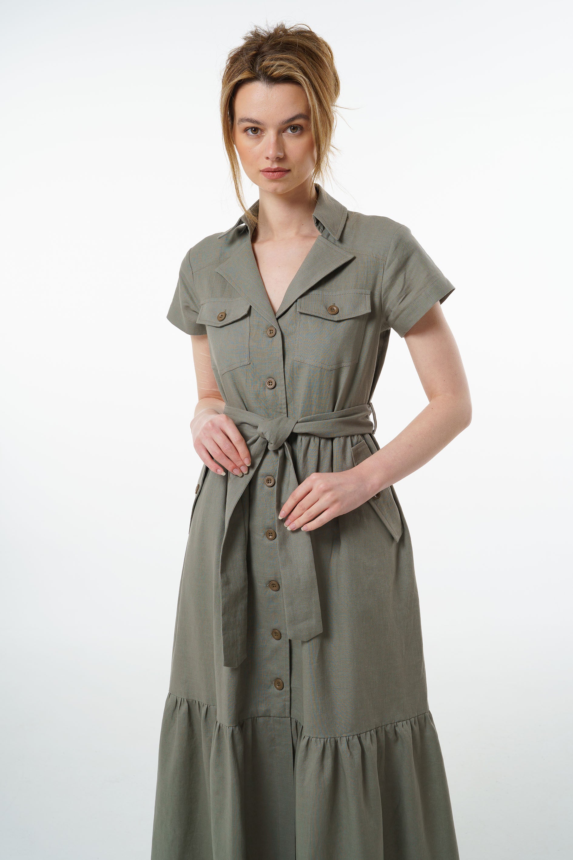 Olive green linen maxi dress with button front, belted waist, and gathered tiered hem, worn by a model, front studio view.