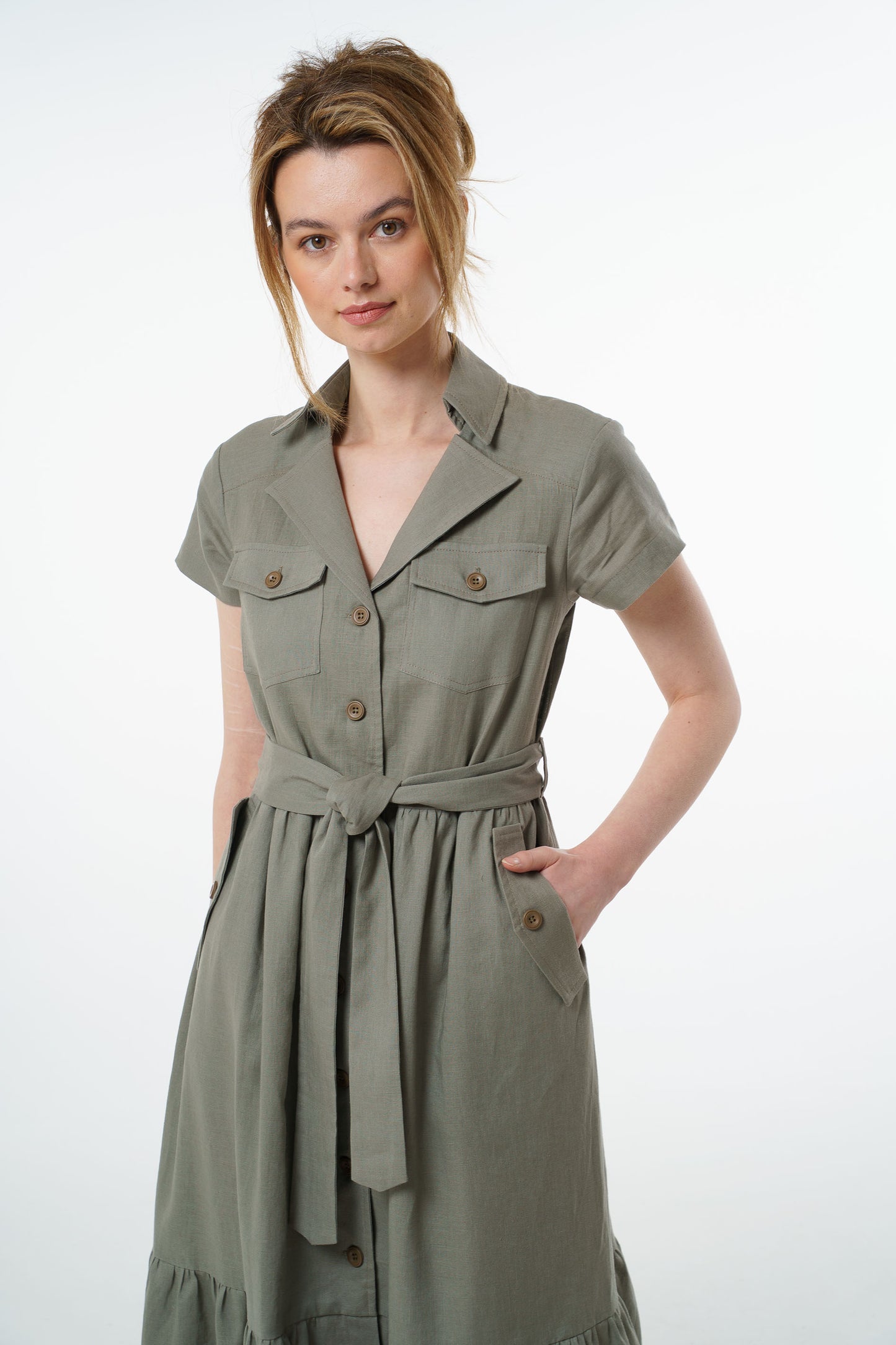 Close‑up of olive green linen button‑down dress showing collared neckline, chest pockets, and short sleeves.