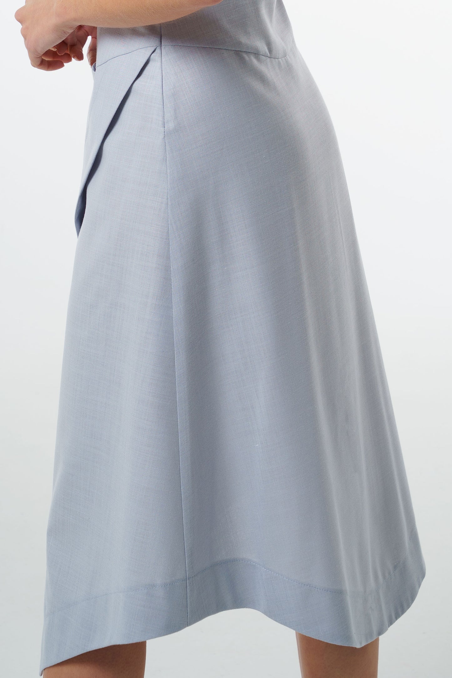 Close‑up of pale blue midi skirt with side seam and textured woven fabric.