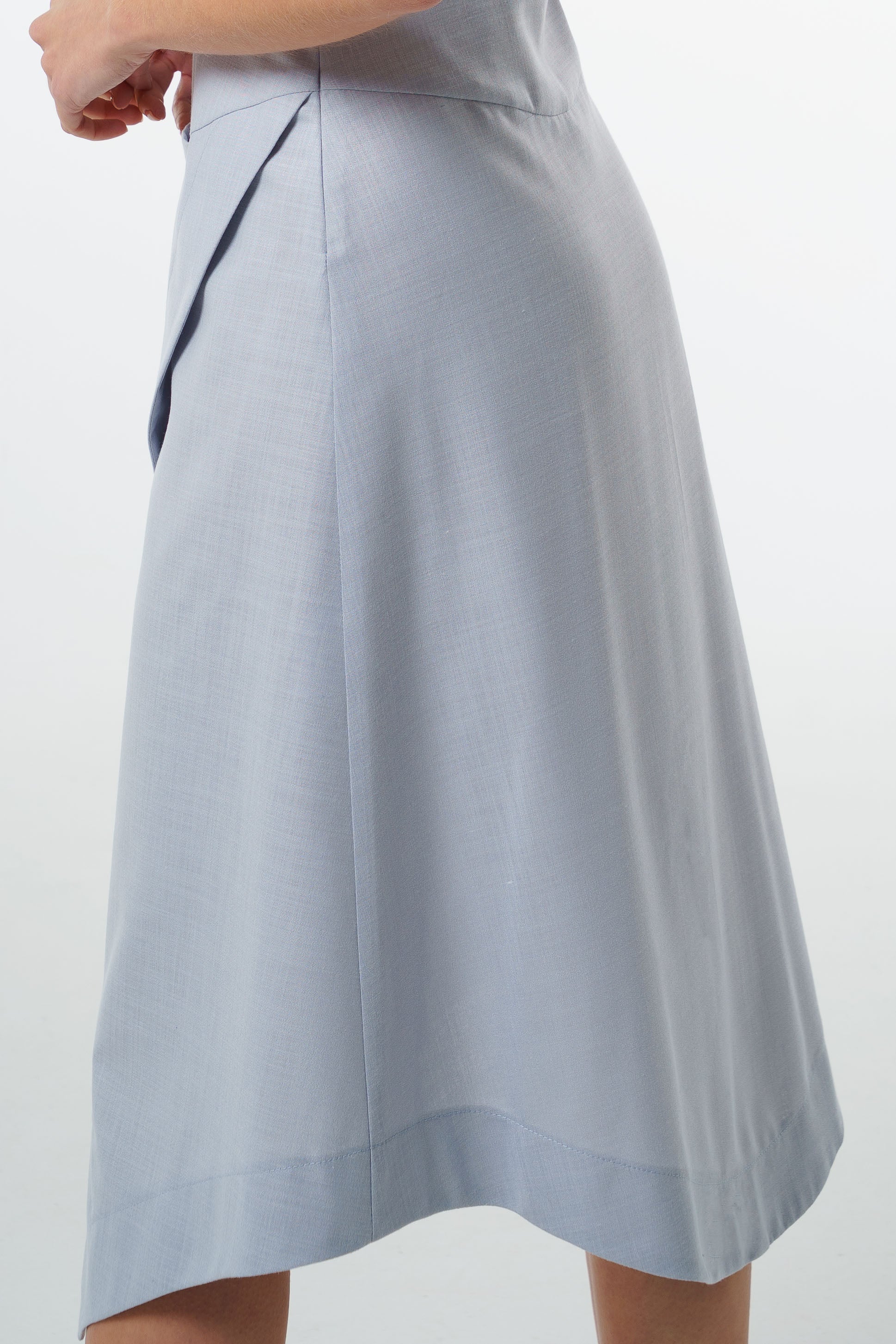 Close‑up of pale blue midi skirt with side seam and textured woven fabric.