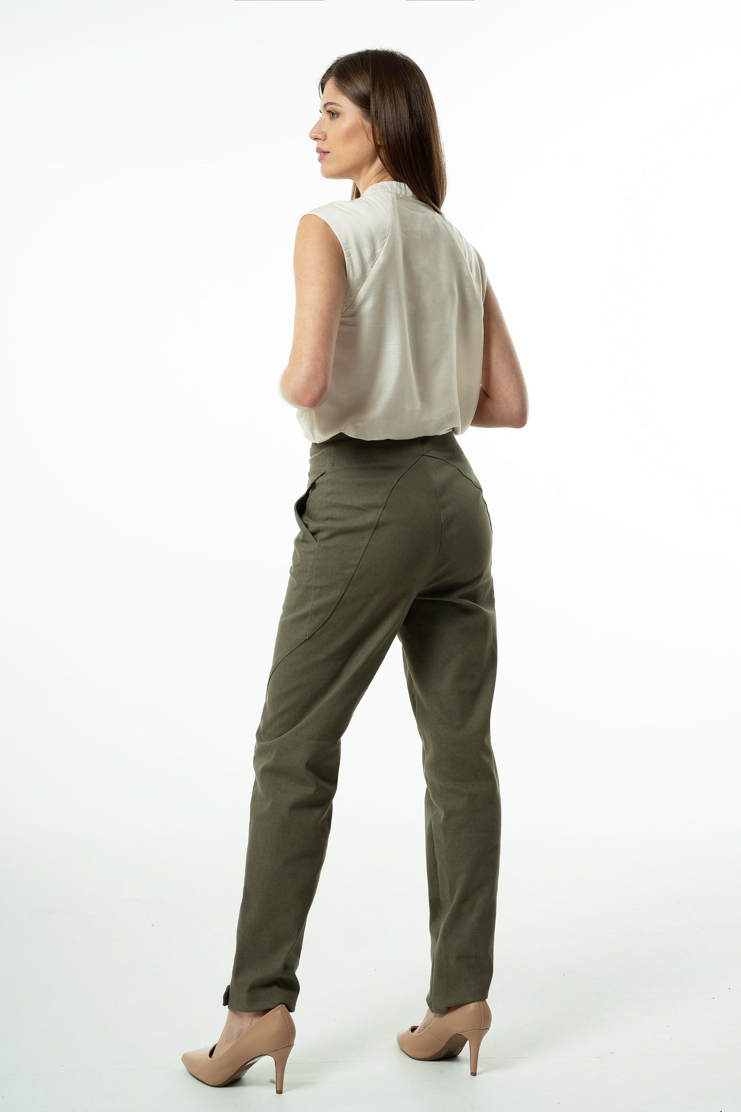 Olive high‑waisted stretch denim trousers with curved back seams and tapered silhouette, worn by a model, angled studio view.