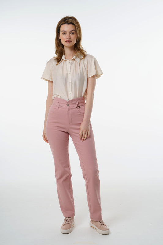 Rose‑dust high‑waisted stretch denim trousers with layered waistband and straight‑leg silhouette, worn by a model with a cream short‑sleeve blouse, front studio view.