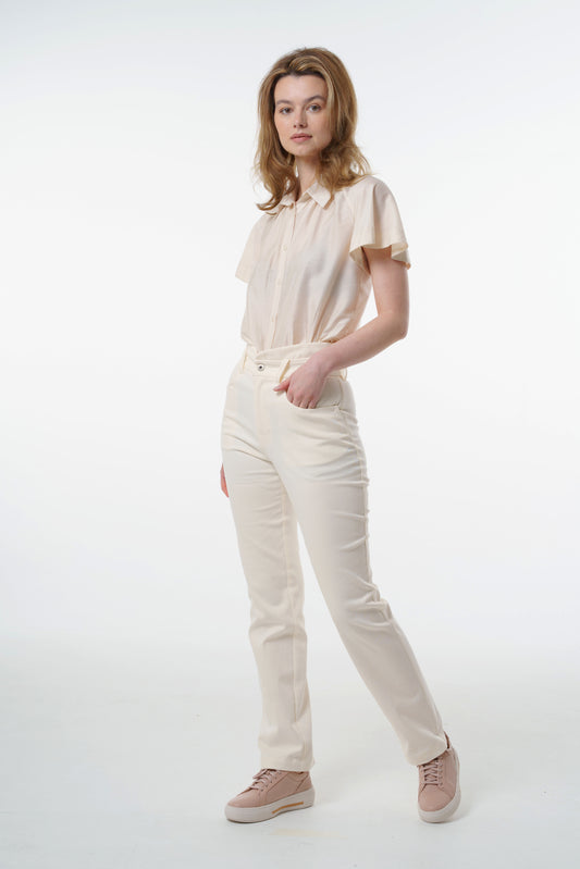 Cream high‑waisted stretch denim trousers with layered waistband, front pockets, and clean straight‑leg line, worn by a model, front studio shot.