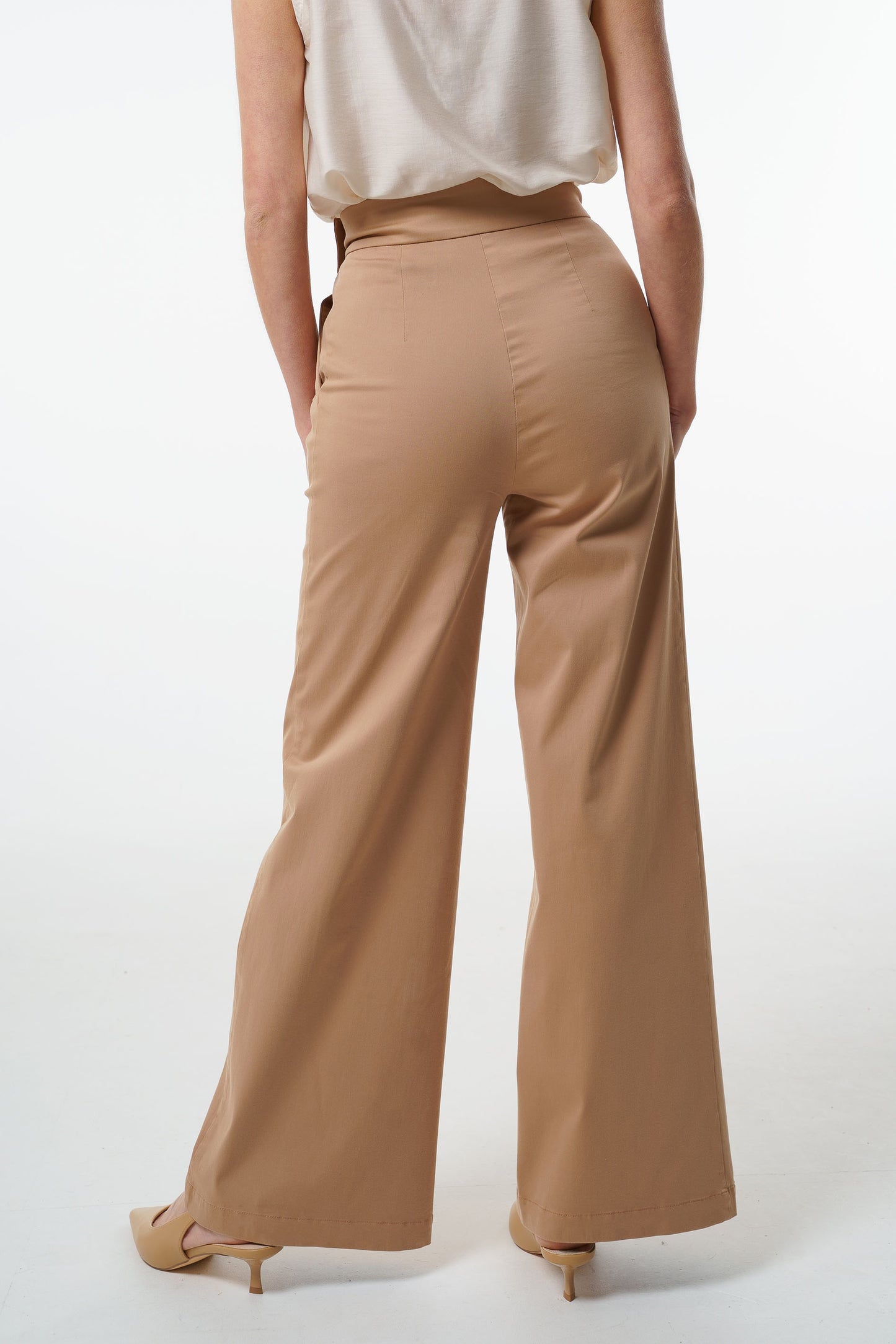 - High‑waisted wide‑leg trousers with an adjustable side‑button waistband and clean back drape, worn by a model, back studio view.