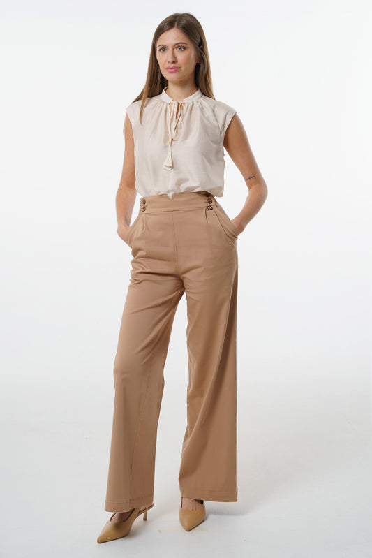 High‑waisted wide‑leg trousers featuring an adjustable side‑button waistband and soft pleated structure, worn by a model with a sleeveless blouse, front studio view.