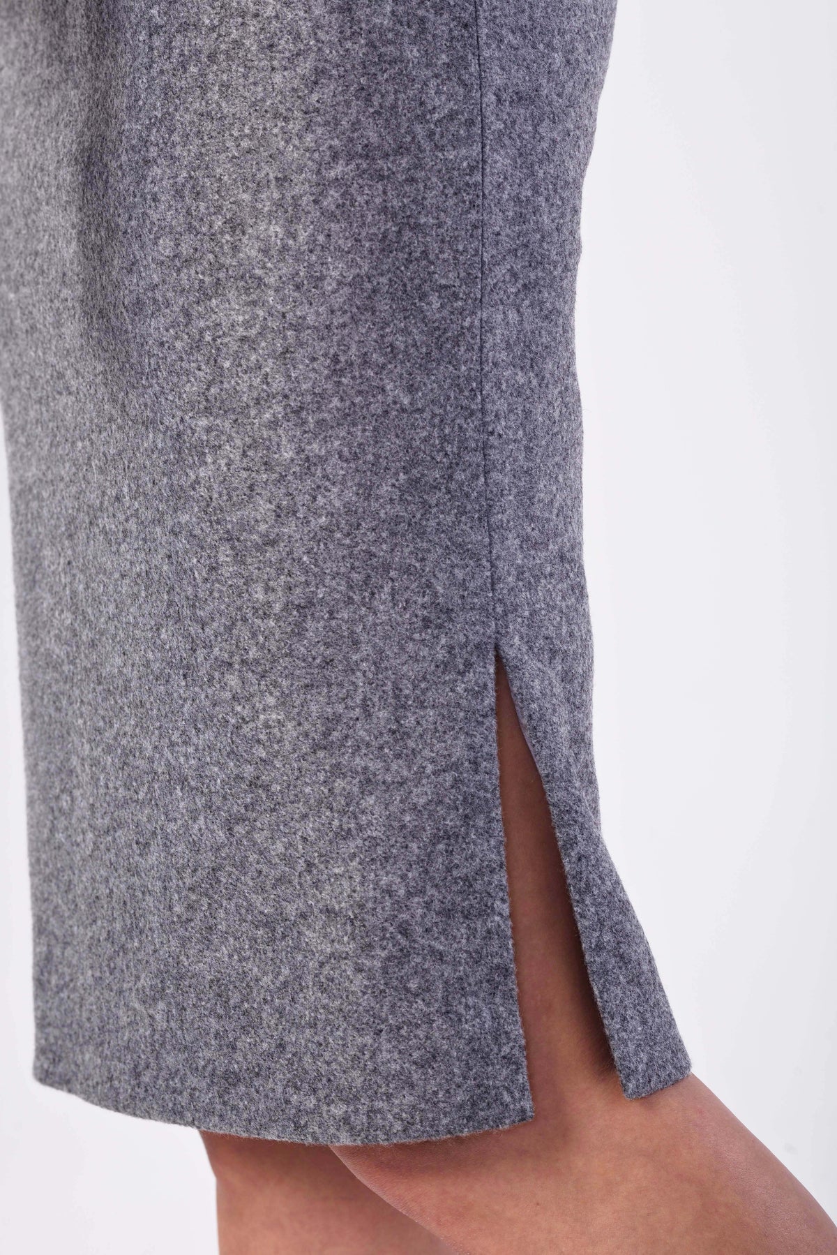 Close-up of a gray textured wool blend skirt with a side slit, worn by a model against a plain white background.