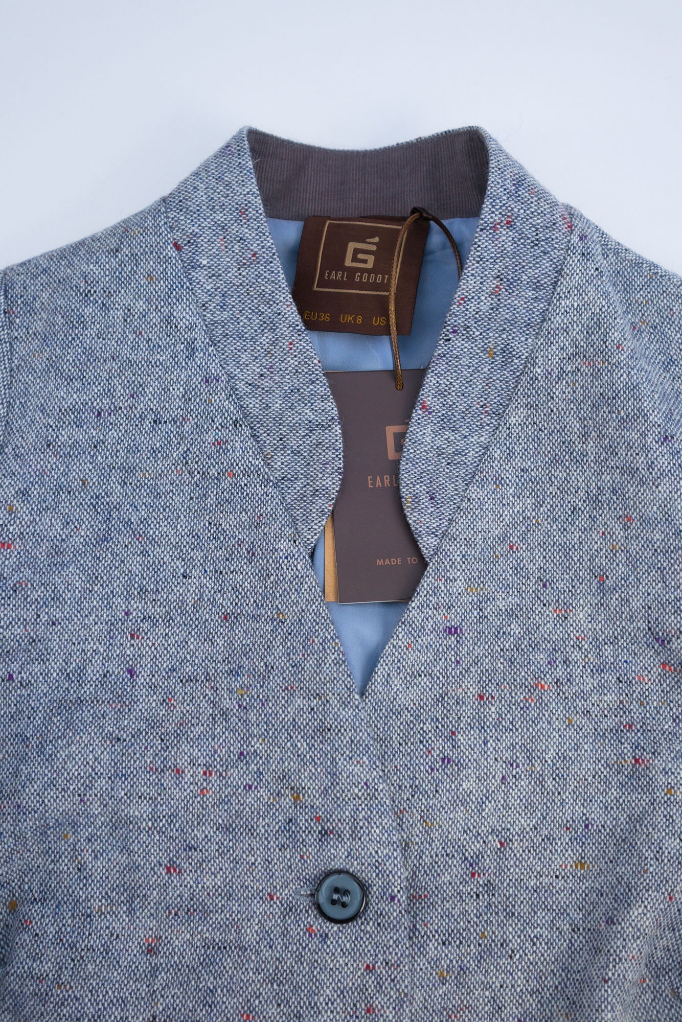 Close up of a light blue wool tailored midi dress with  subtle speckled texture, showing stand up collar, flat studio view.