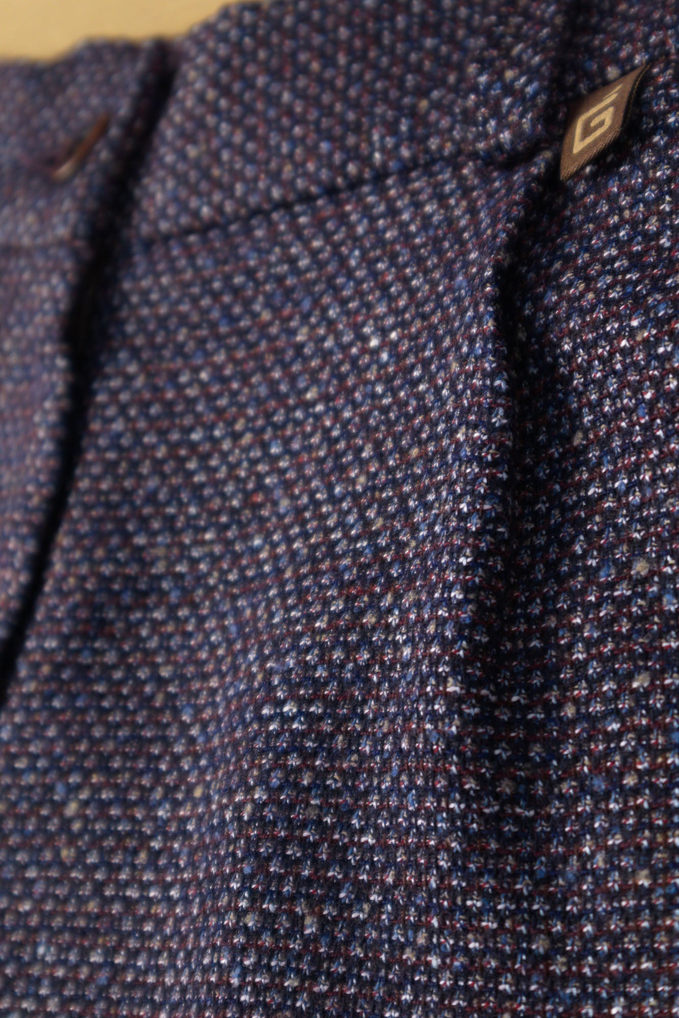 Macro detail view of the multi-tonal fabric weave and signature logo tab on the shorts.