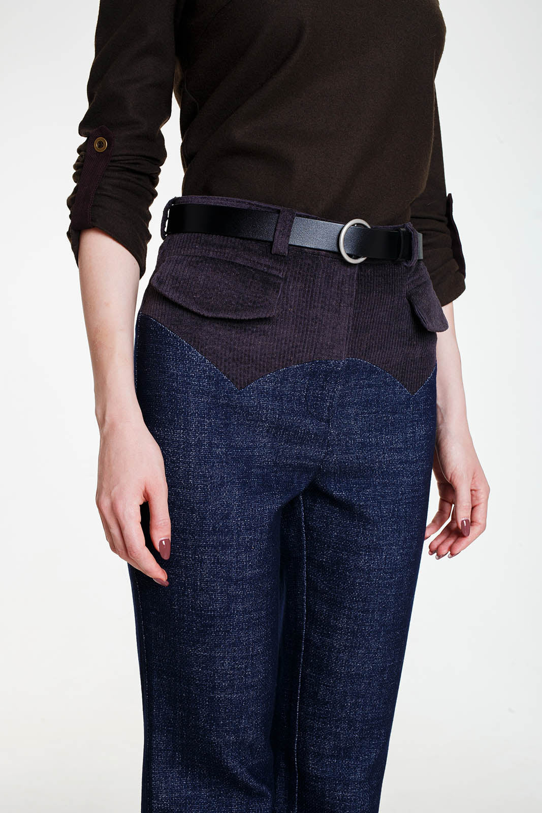 A mid-section front view of the trousers styled with a black leather belt. The image clearly shows the contrast between the blue textured wool fabric and the dark corduroy yoke, which features two symmetrical front pockets with flaps.A mid-section front view of the trousers styled with a black leather belt. The image clearly shows the contrast between the blue textured wool fabric and the dark corduroy yoke, which features two symmetrical front pockets with flaps.