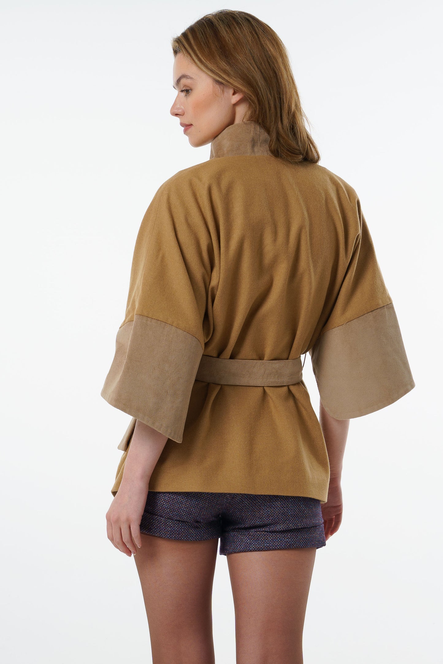 Full back view of a camel-colored belted jacket showing the oversized kimono-style volume and elegant drape.