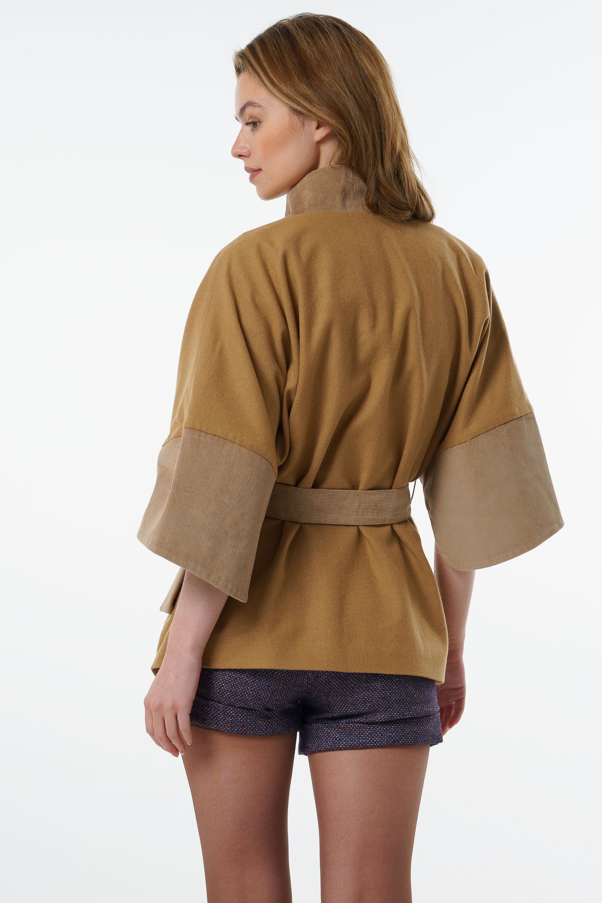 Full back view of a camel-colored belted jacket showing the oversized kimono-style volume and elegant drape.