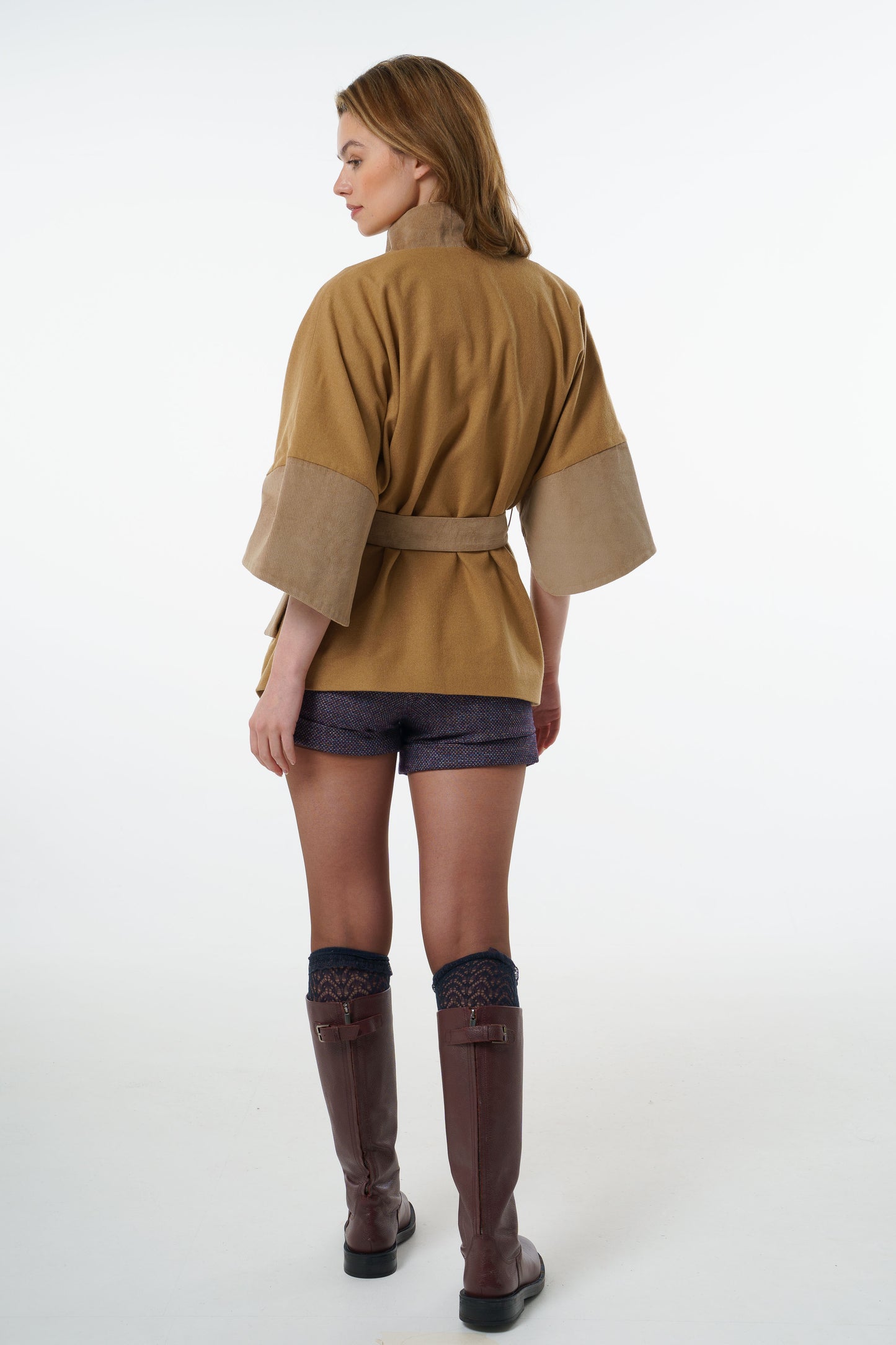 Full back view of a camel-coloured belted jacket showing the oversized kimono-style volume and elegant drape.