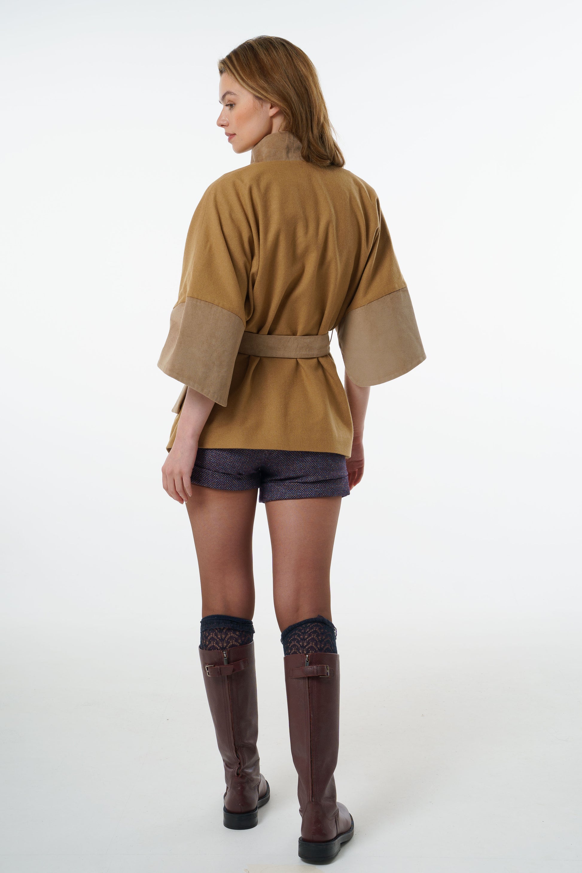 Full back view of a camel-coloured belted jacket showing the oversized kimono-style volume and elegant drape.