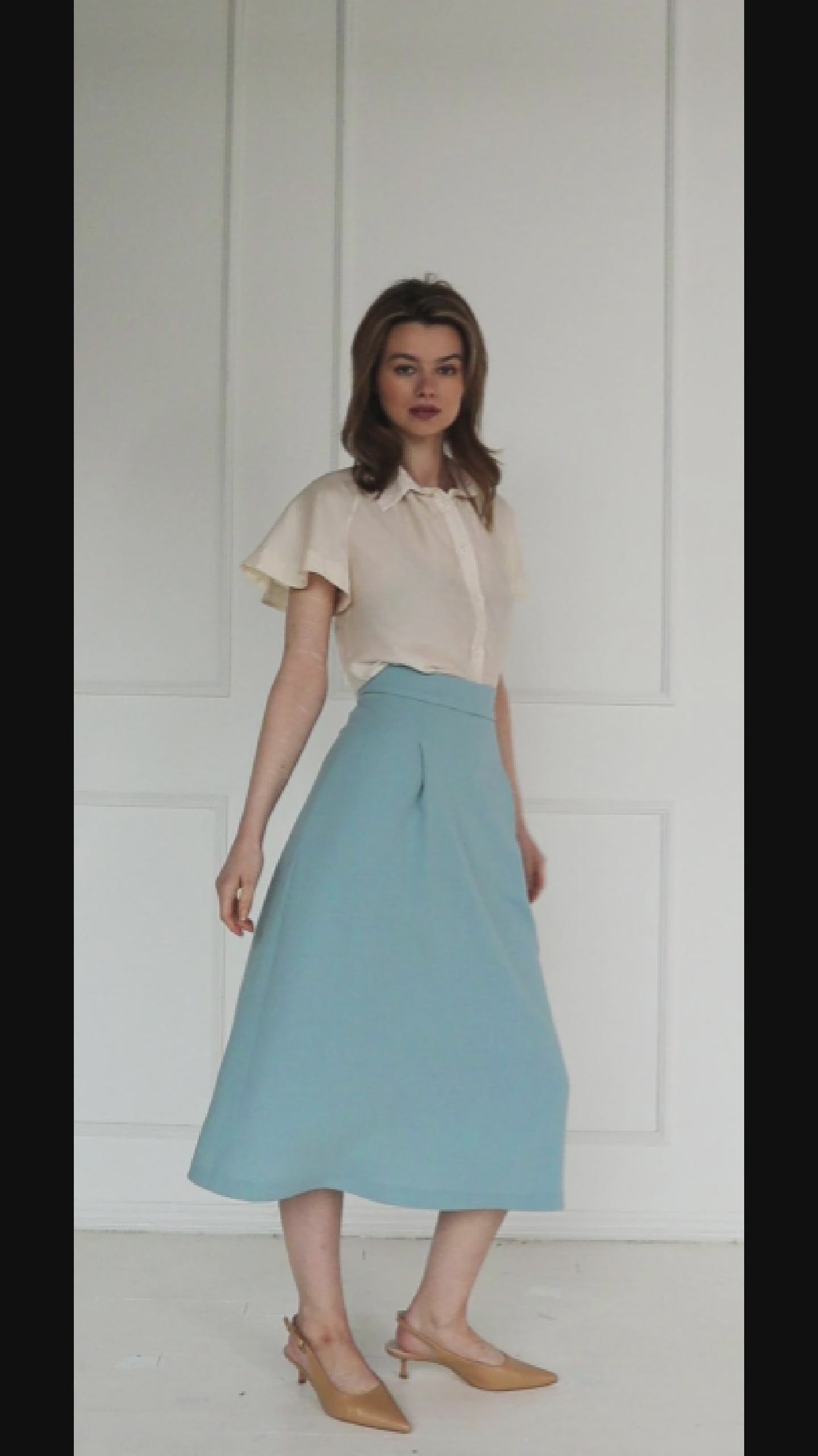 A studio video showing the ivory short‑sleeve silk–viscose blouse, highlighting the flared raglan sleeves, fluid drape, and soft sheen of the fabric.