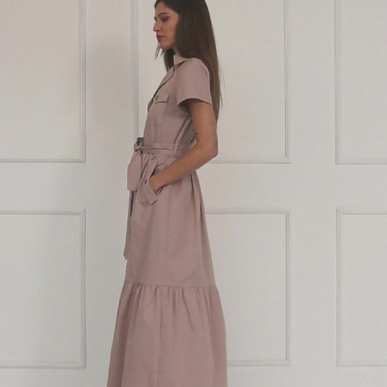 A studio video showing a model wearing the dusty mauve cotton button‑down maxi shirt-dress, highlighting the belted waist, tiered skirt, and the soft drape of the lightweight cotton.