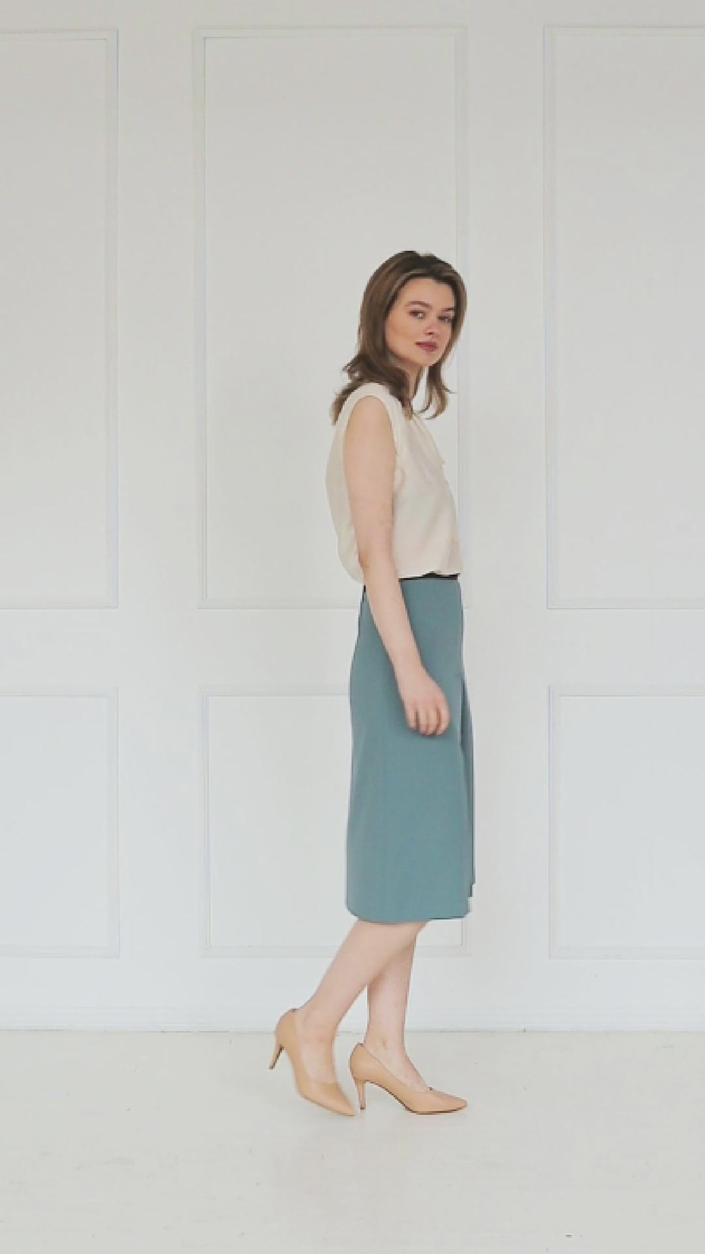 A studio video showing the ivory sleeveless silk–viscose blouse, highlighting the front tie detail, fluid drape, and soft sheen of the fabric.