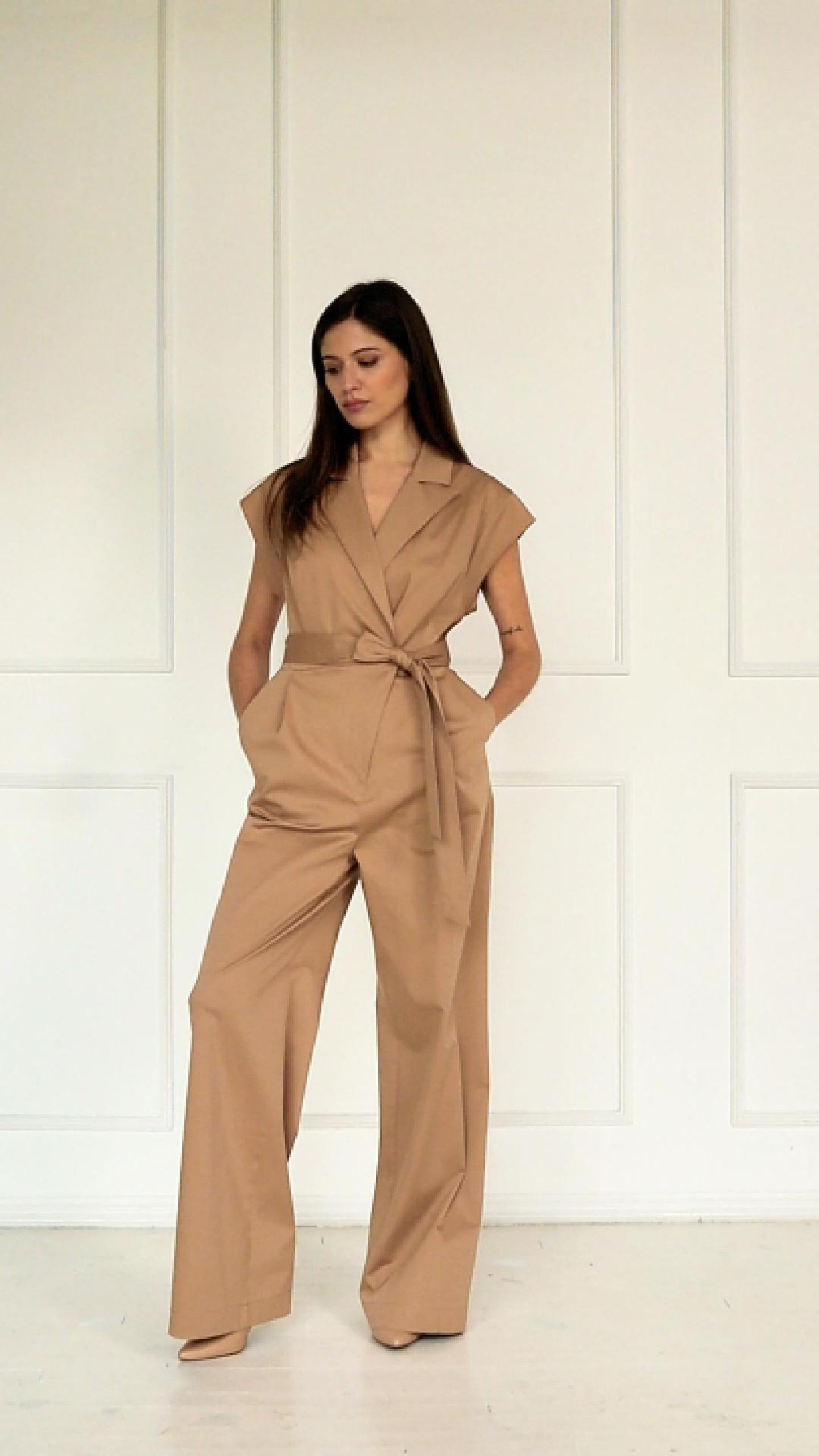 A studio video showing the camel wrap‑front wide‑leg jumpsuit in a cotton–viscose blend, highlighting the drape, tied waist, and relaxed wide‑leg silhouette.